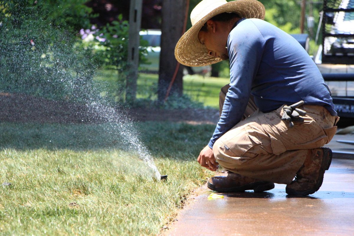 Skilled technicians from Lakeland Irrigation Pros meticulously installing a state-of-the-art irrigation system in a beautiful residential garden.